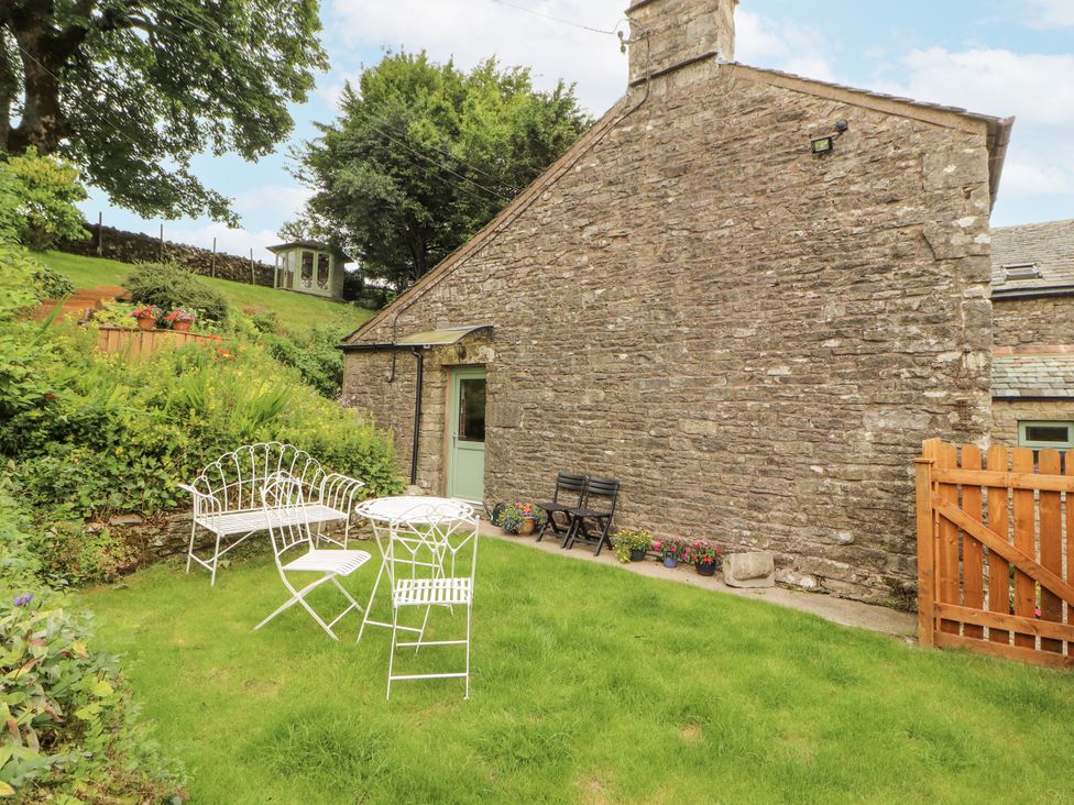A garden with a table and chairs at White House in Shap