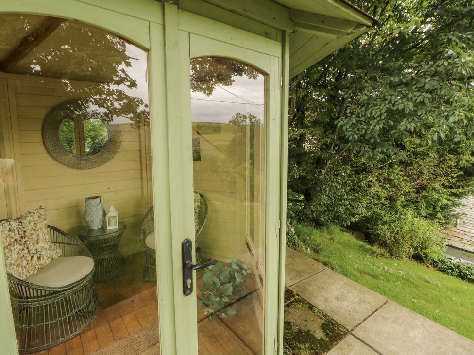 A garden room with chairs and a table at White House in Shap