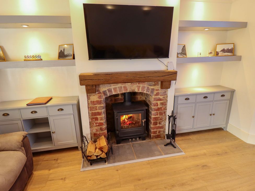 A living room with a fireplace and television at 9 Alford Road 