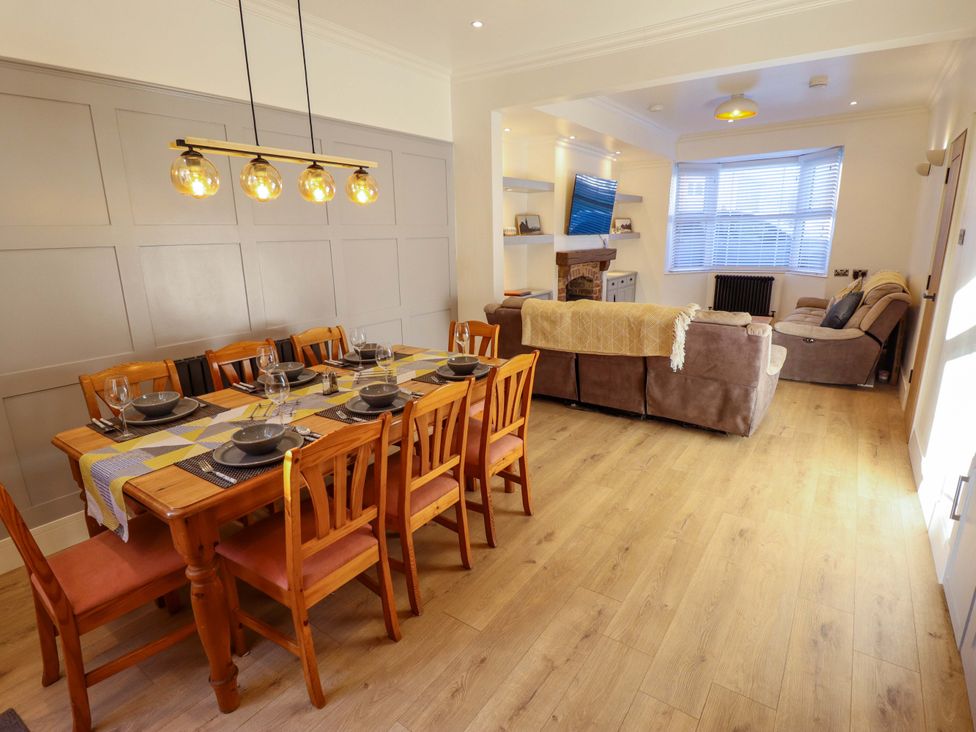 A dining room with a long table and sofa at 9 Alford Road