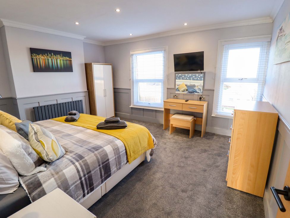 A bedroom with a bed, dresser, and wardrobe at 9 Alford Road