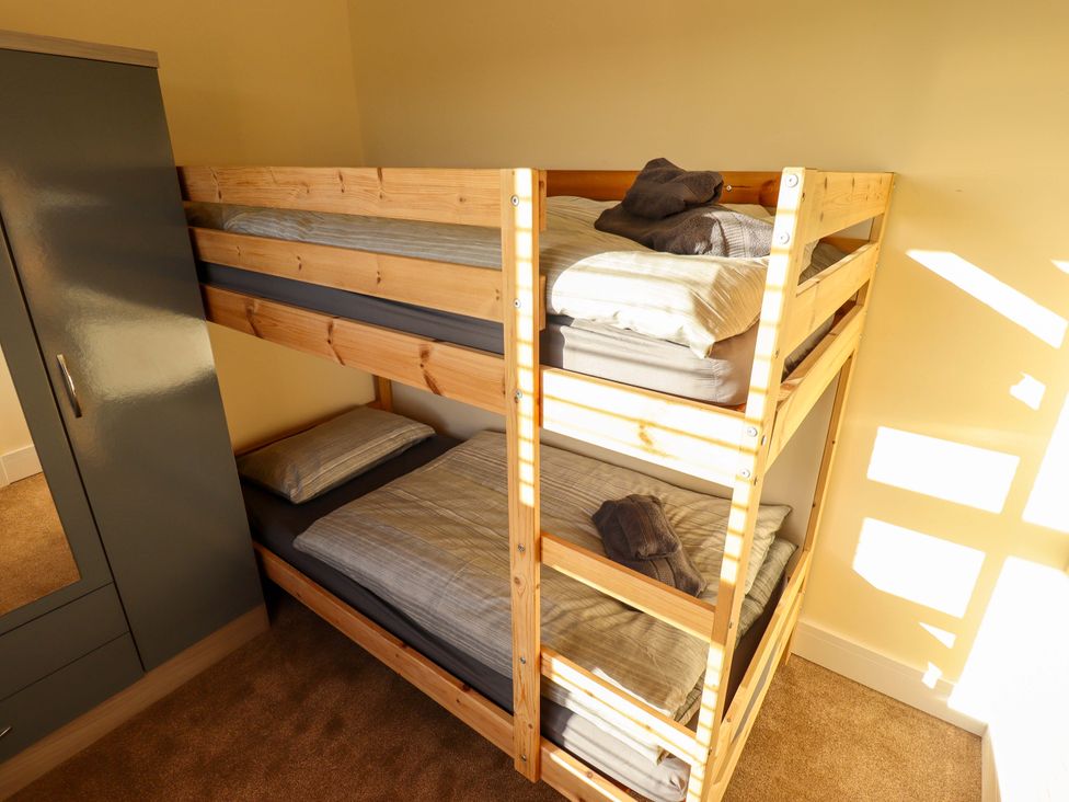 A bunk bed with bedding and a wardrobe at 9 Alford Road