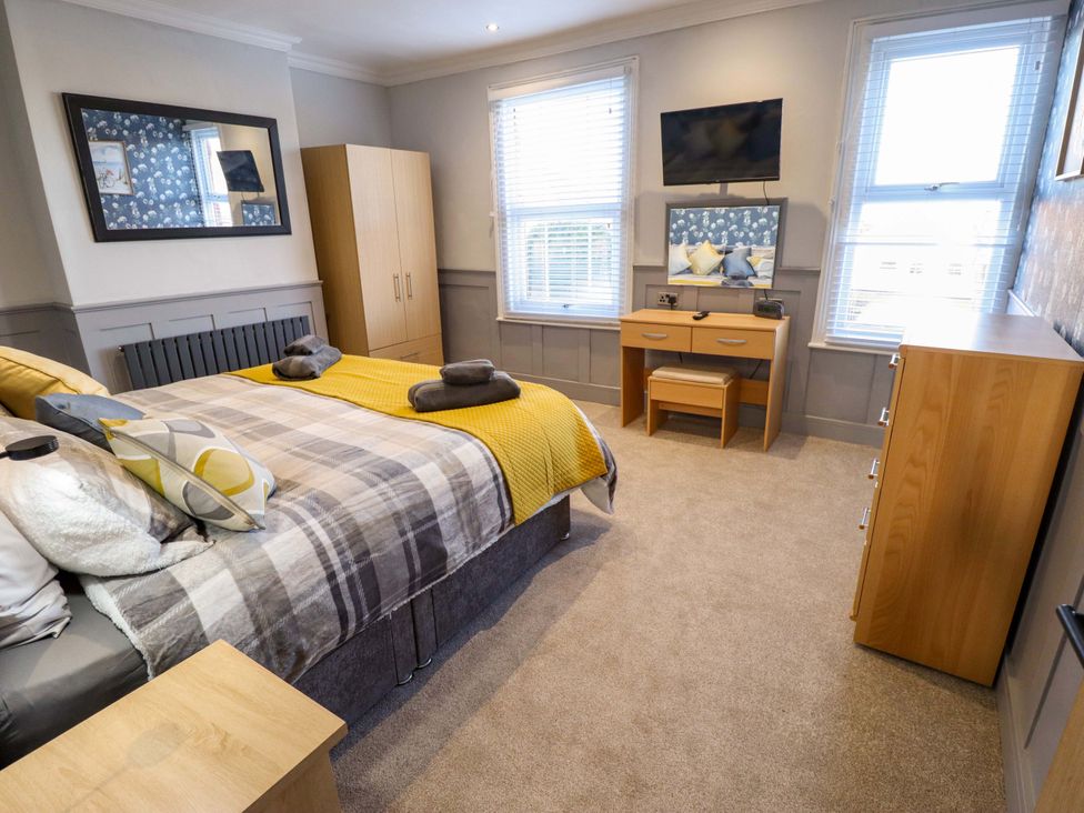 A bedroom with a bed, wardrobe, and desk at 9 Alford Road