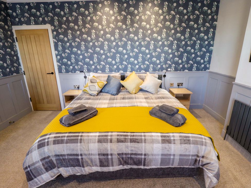 A bedroom with a bed and bedside tables at 9 Alford Road 