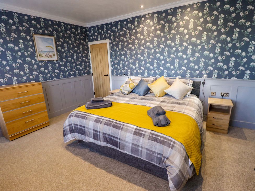 A bedroom with a bed, nightstand, and chest of drawers at 9 Alford Road