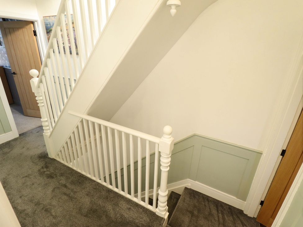 A staircase with white railings and a door at 9 Alford Road