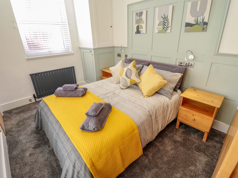 A bedroom with a bed and bedside table at 9 Alford Road