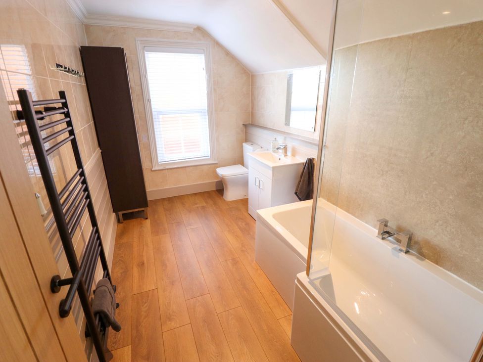 A bathroom with tub, toilet, and sink at 9 Alford Road