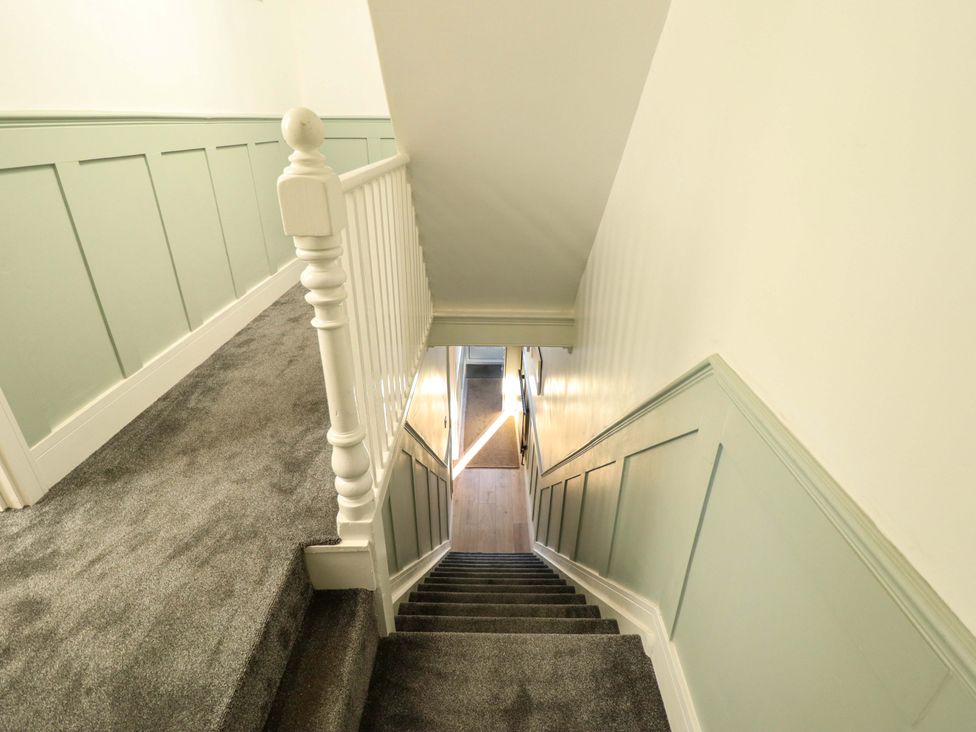 A staircase with a handrail leading to a hallway at 9 Alford Road