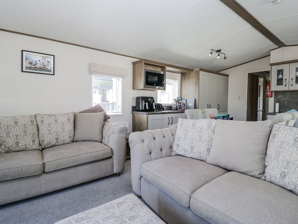 A living room with sofas and a television at Lilac Lodge in Carnforth