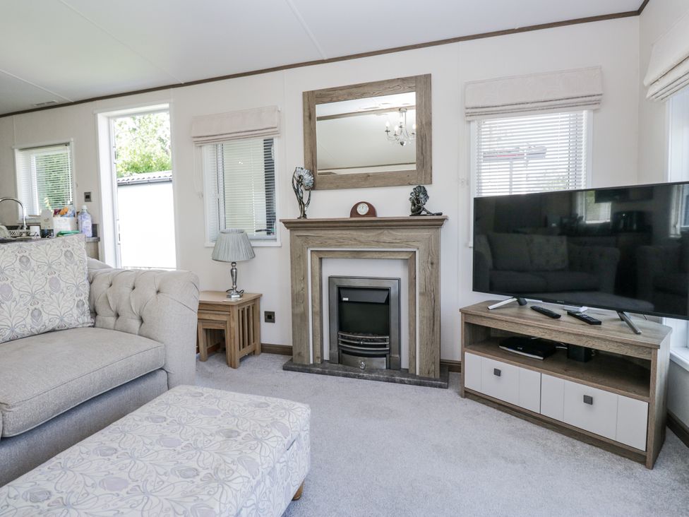 A living room with a sofa and fireplace at Lilac Lodge in Carnforth