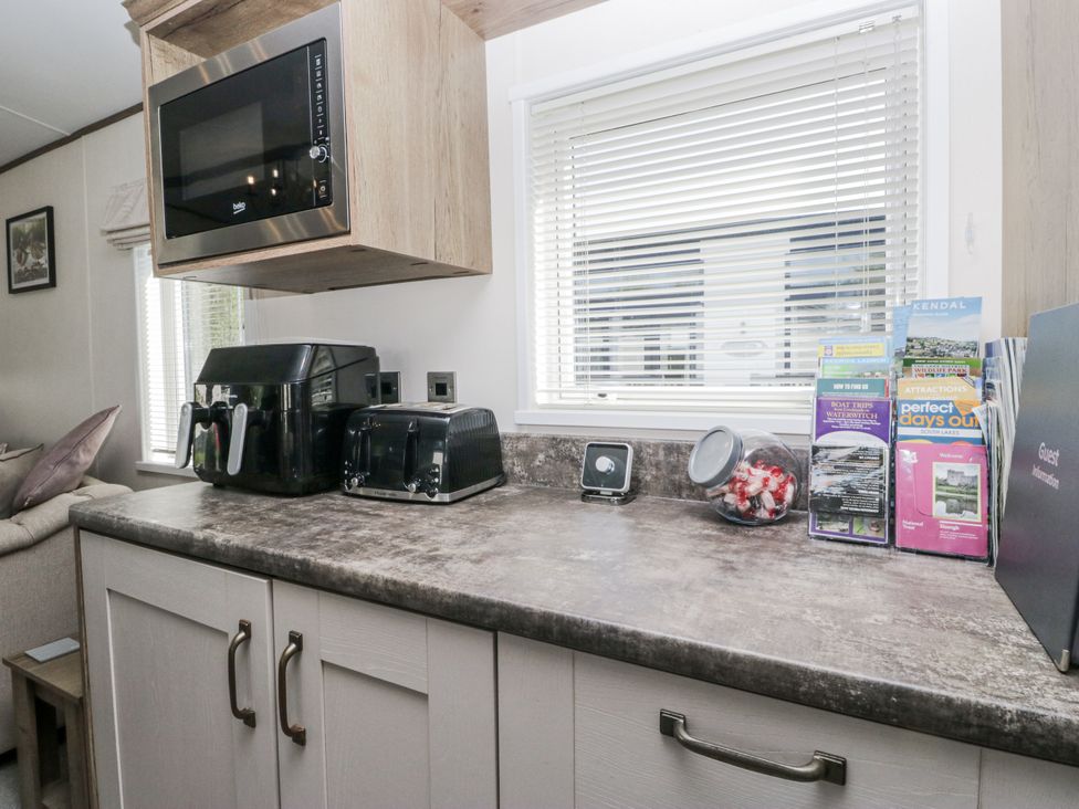 A kitchen countertop with appliances and brochures at Lilac Lodge in Carnforth