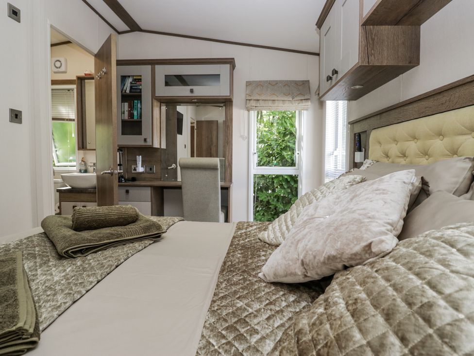 A bedroom with a bed and desk at Lilac Lodge in Carnforth