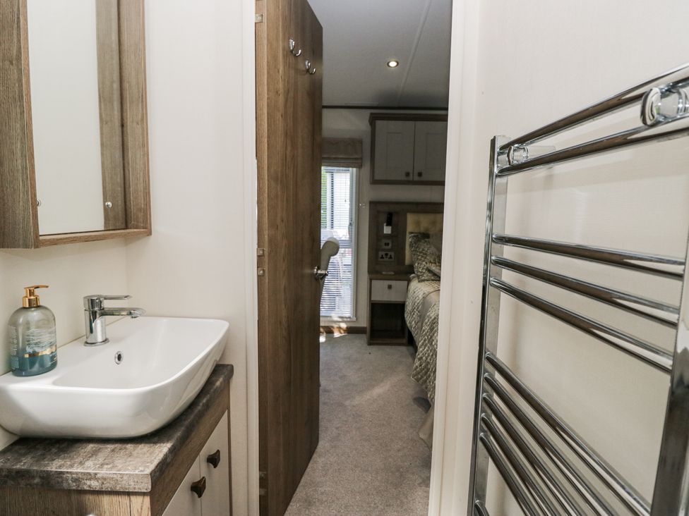 A bathroom with a sink and mirror at Lilac Lodge in Carnforth