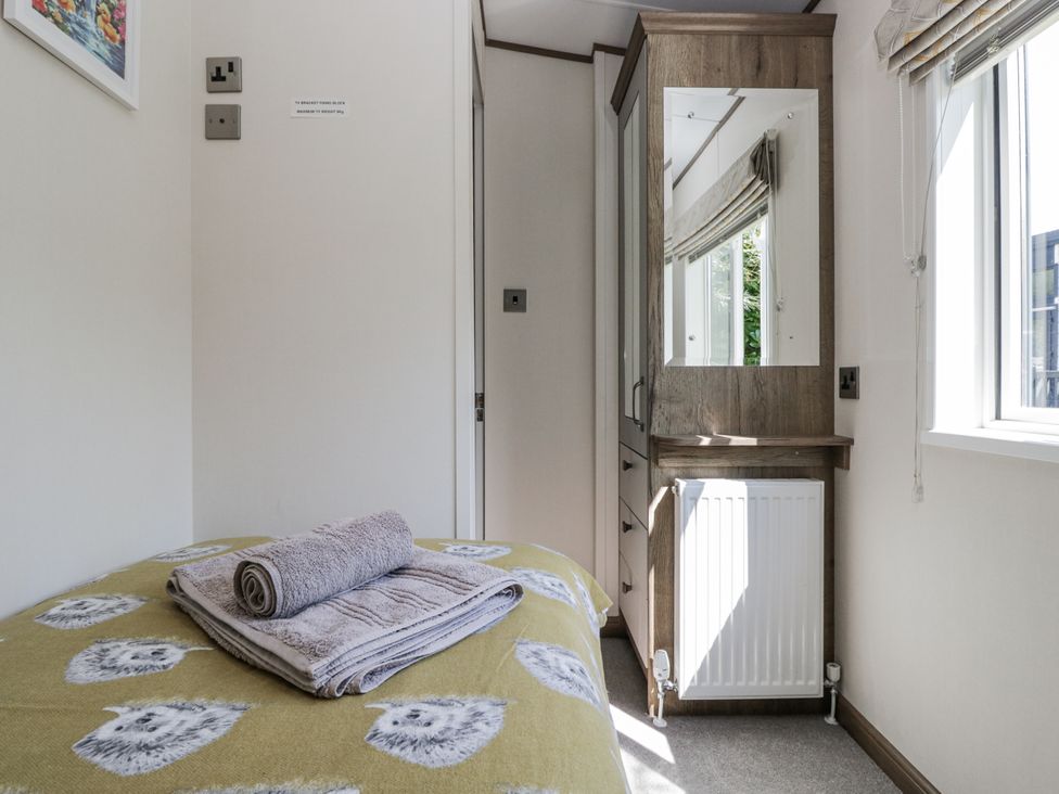 A bedroom with a bed and towels at Lilac Lodge Carnforth
