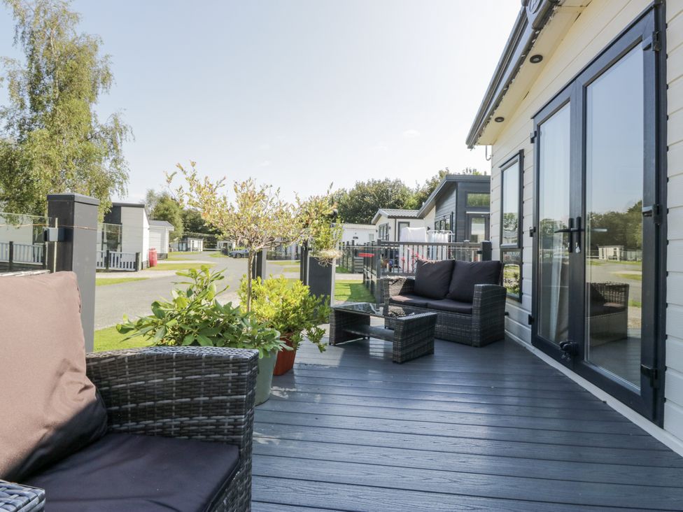An outdoor seating area with chairs and a table at Lilac Lodge in Carnforth