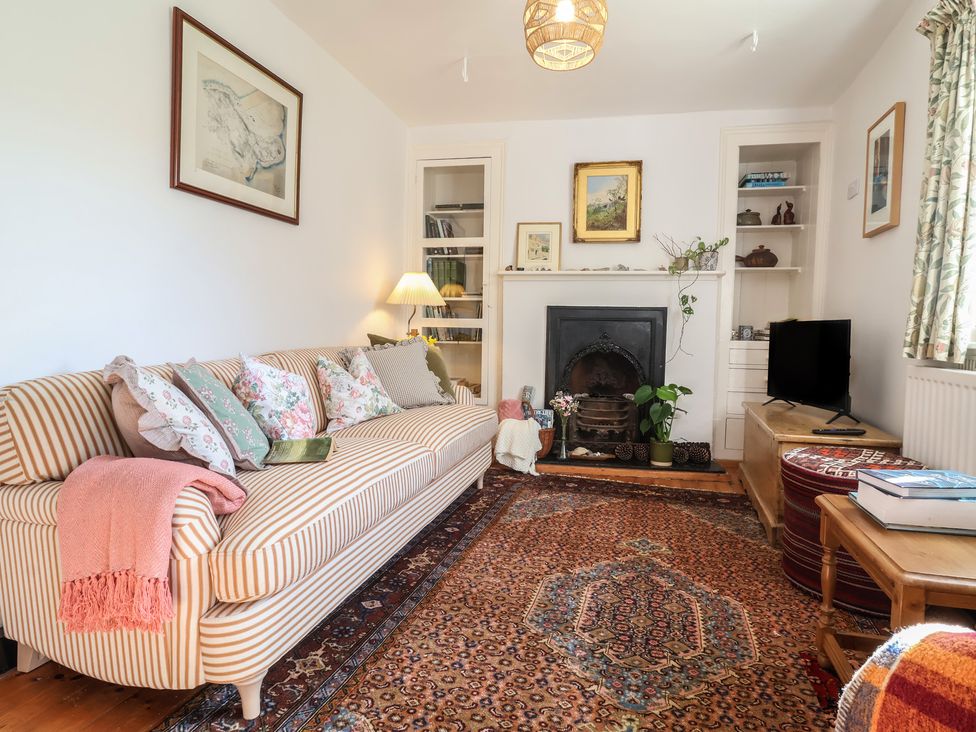 A living room with a sofa and fireplace at Blackbird Cottage in Northam
