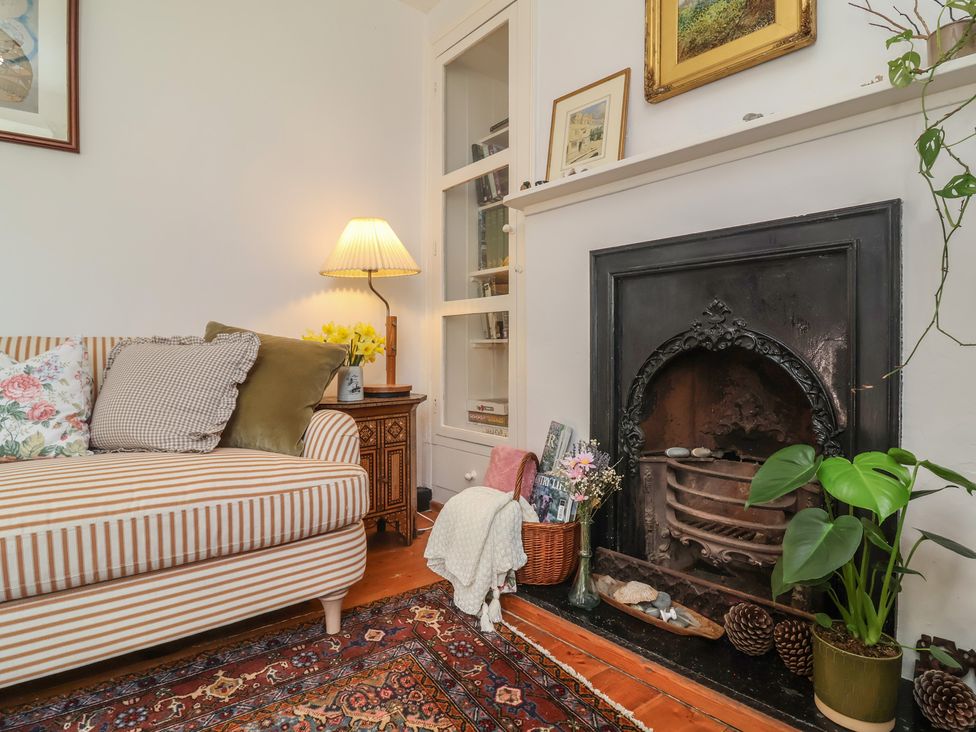A living room with a sofa and fireplace at Blackbird Cottage in Northam