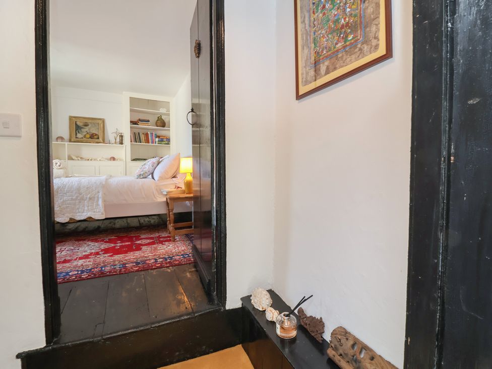 A bedroom with a bed and bookshelf at Blackbird Cottage Northam