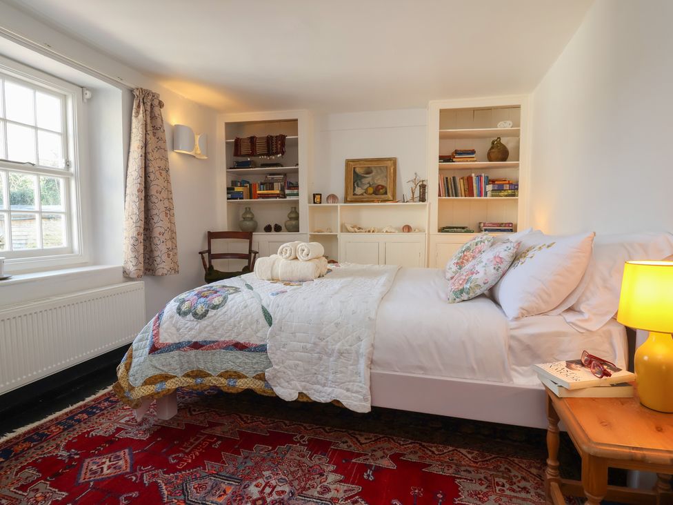 A bedroom with a bed and bookshelf at Blackbird Cottage Northam