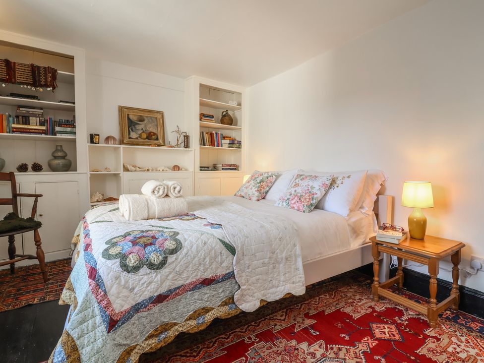 A bedroom with a bed and bookshelf at Blackbird Cottage Northam
