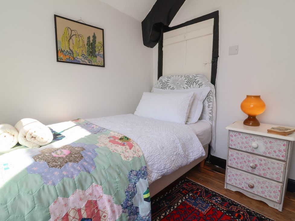 A bedroom with a bed and bedside table at Blackbird Cottage Northam