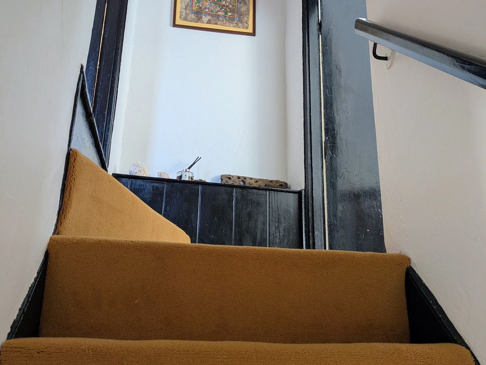 A staircase with a wall and a picture frame at Blackbird Cottage Northam