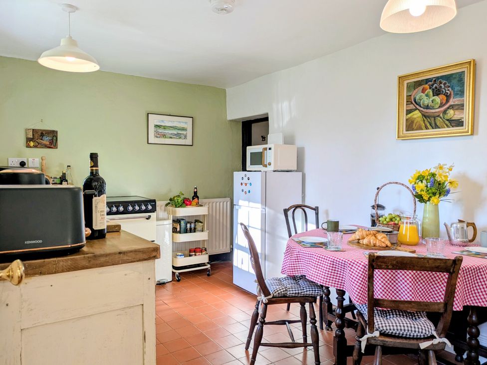 A kitchen with a table and chairs at Blackbird Cottage in Northam