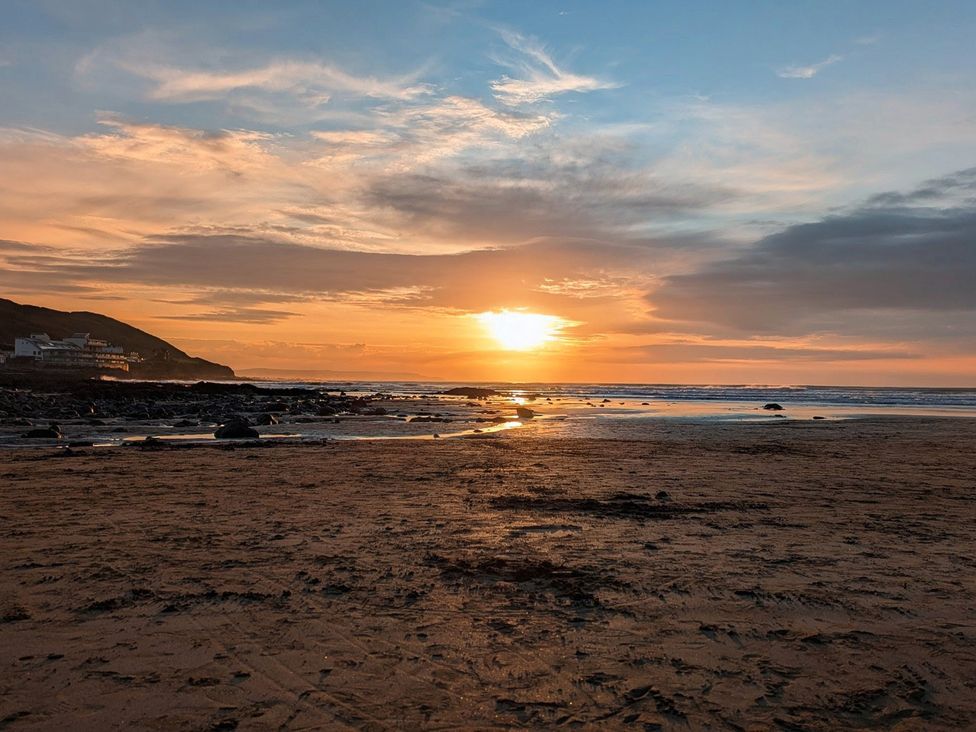 A beach during sunset at Blackbird Cottage in Northam