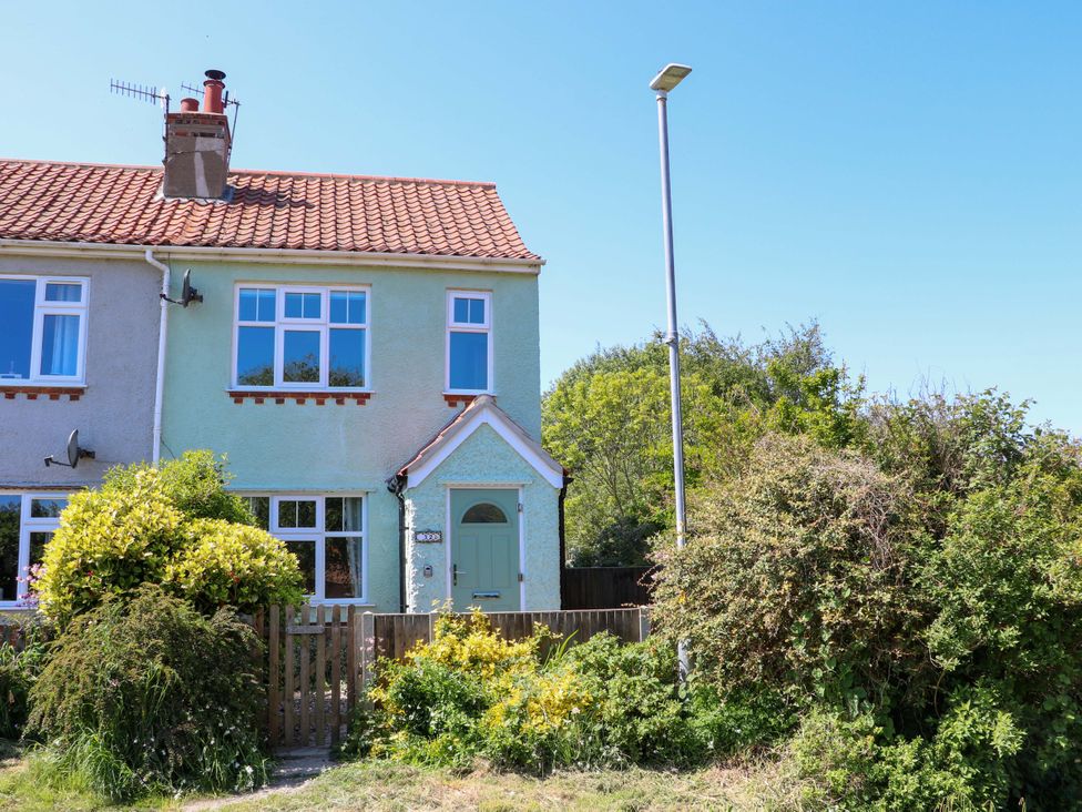 A two-story end terrace house with a front garden and a street lamp at Beck View in Sheringham