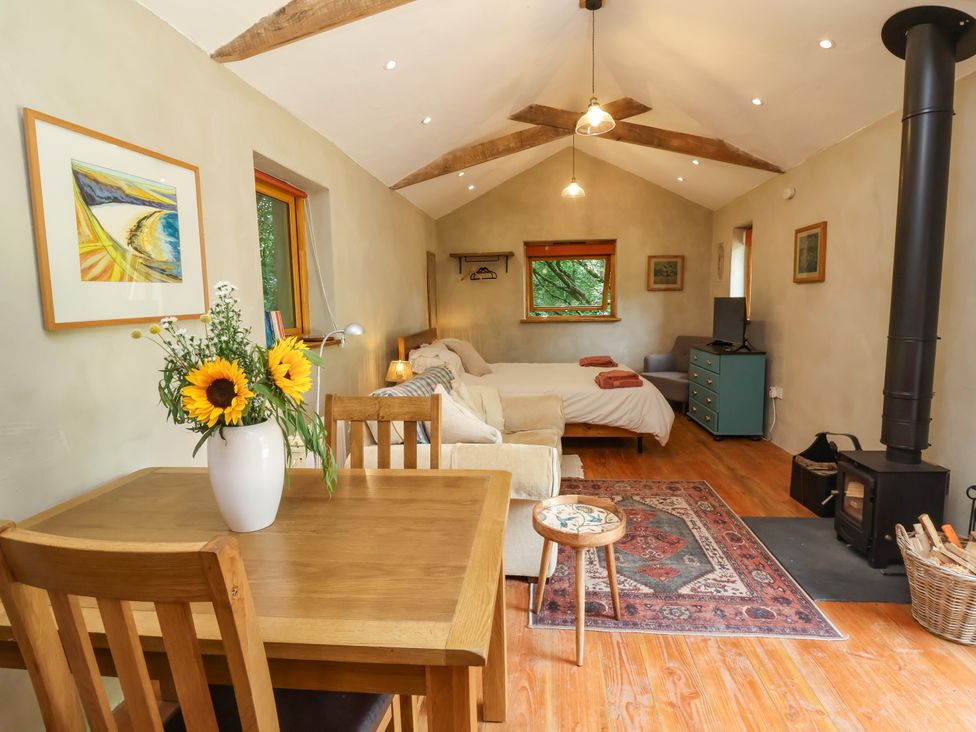 A studio with a bed and dining table at Brambly Cabin in Crediton