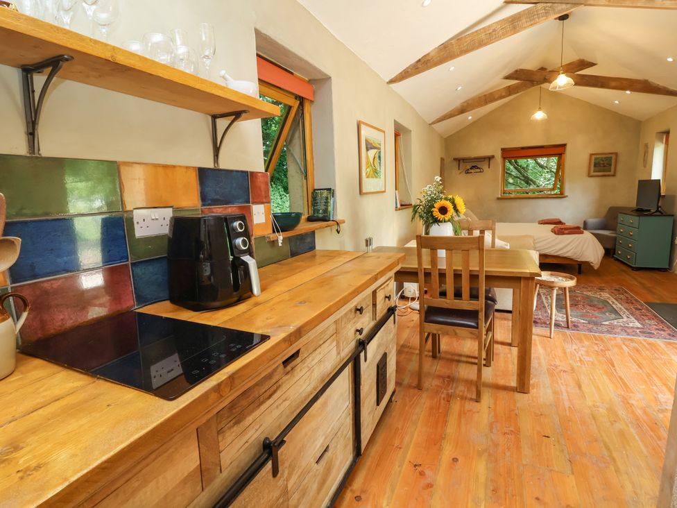 A kitchen with wooden furniture and a coffee maker at Brambly Cabin in Crediton