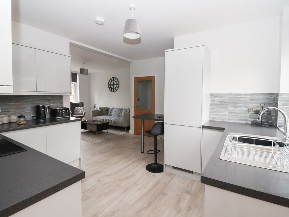 A kitchen with a countertop and barstools at Waters View in Skipton