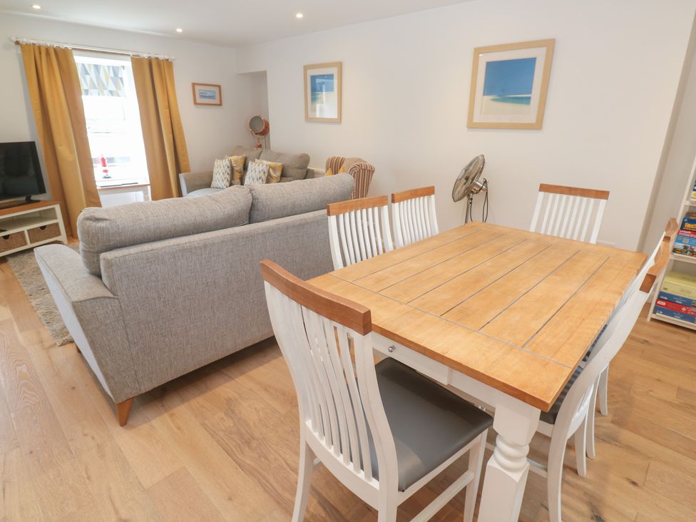 A living room with a sofa and dining table at Foundry Cottage In Hayle Harbour Hayle