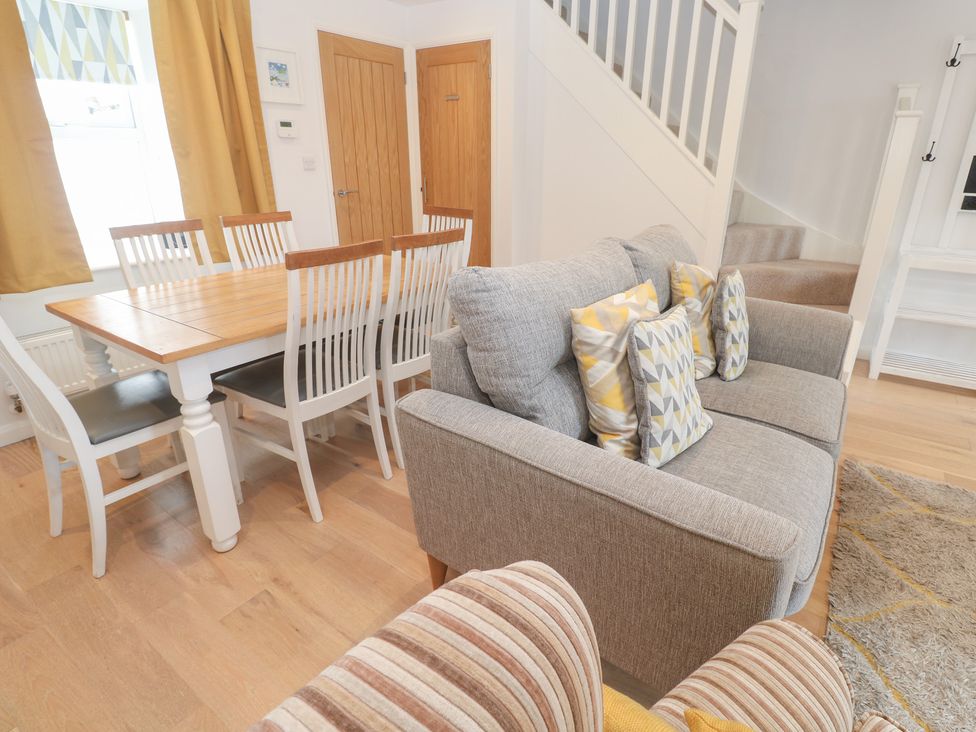 A living room with a dining area featuring a table and chairs at Foundry Cottage In Hayle Harbour in Hayle
