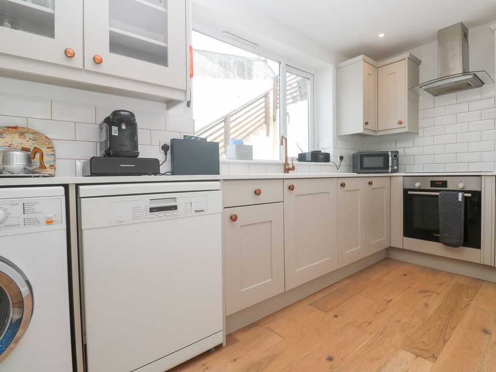 A kitchen with appliances including a washing machine and dishwasher at Foundry Cottage In Hayle Harbour Hayle