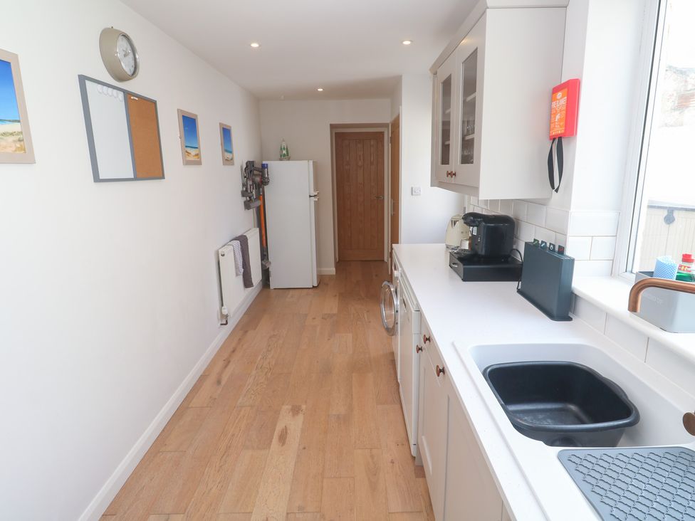 A kitchen with a fridge and kitchen sink at Foundry Cottage In Hayle Harbour, Hayle