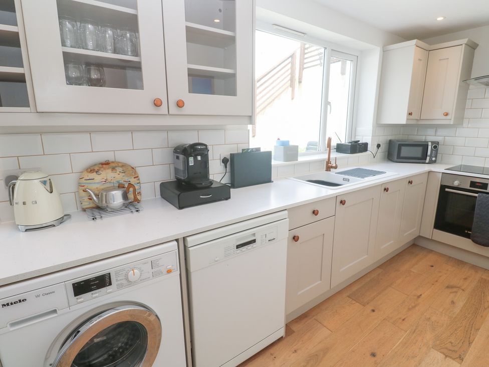 A kitchen with appliances and cabinets at Foundry Cottage In Hayle Harbour Hayle