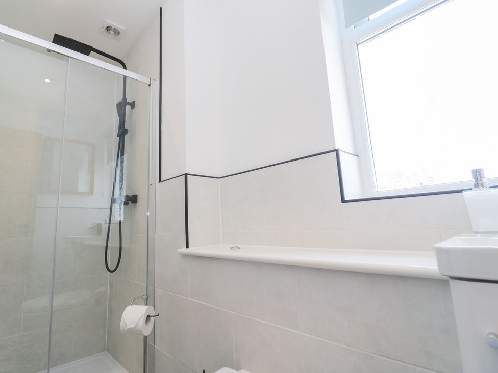 A bathroom with a shower, toilet, and sink at Foundry Cottage In Hayle Harbour, Hayle