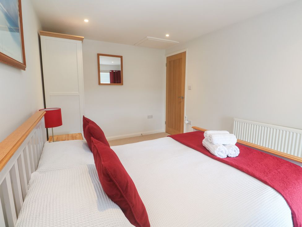 A bedroom with a bed and a lamp at Foundry Cottage In Hayle Harbour Hayle