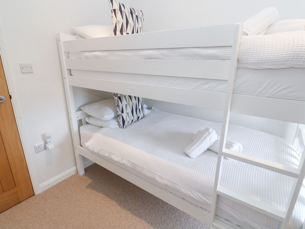 A bunk bed with pillows and towels at Foundry Cottage In Hayle Harbour, Hayle