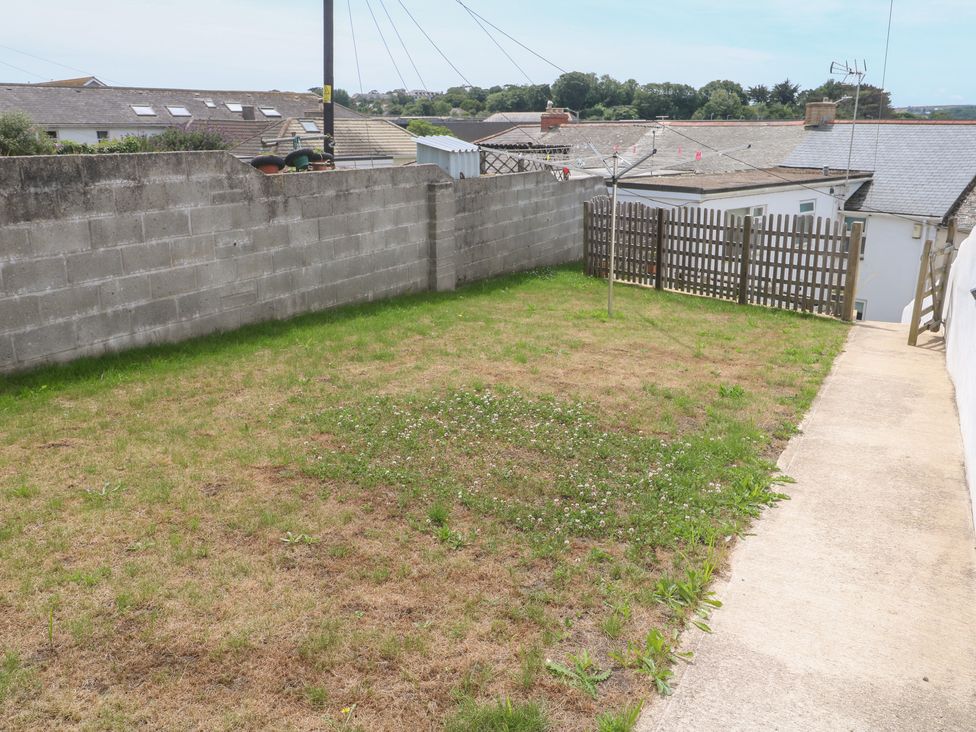 A garden with grass and a fence at Foundry Cottage In Hayle Harbour, Hayle