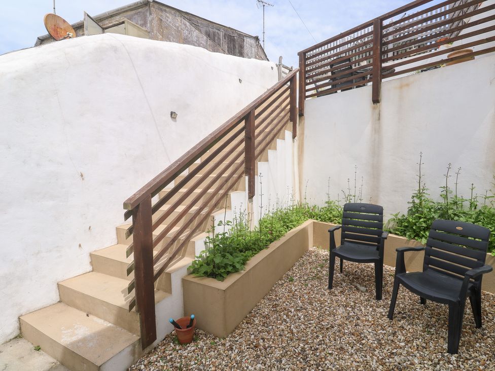 A garden with stairs and chairs at Foundry Cottage In Hayle Harbour, Hayle