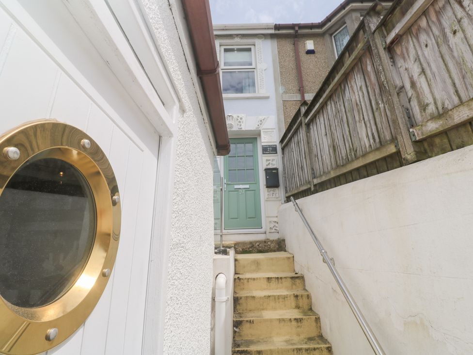 A staircase leading to a front door at Foundry Cottage In Hayle Harbour Hayle