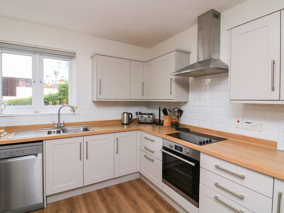 A kitchen with a sink, dishwasher, and oven at Waders in Salcombe