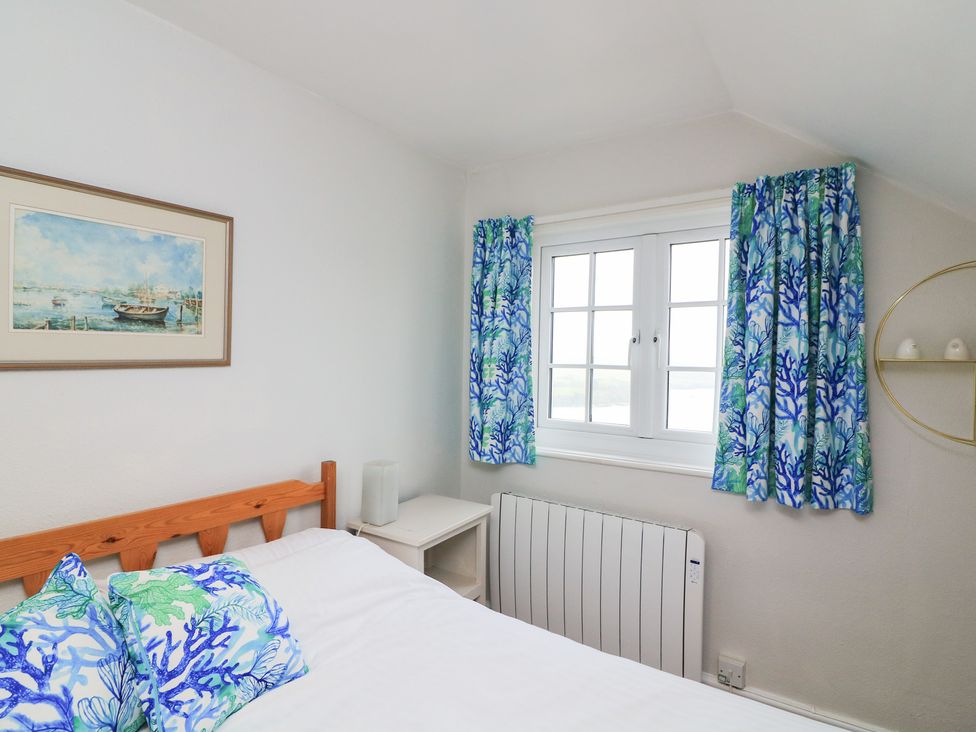 A bedroom with a bed and artwork at Waders in Salcombe