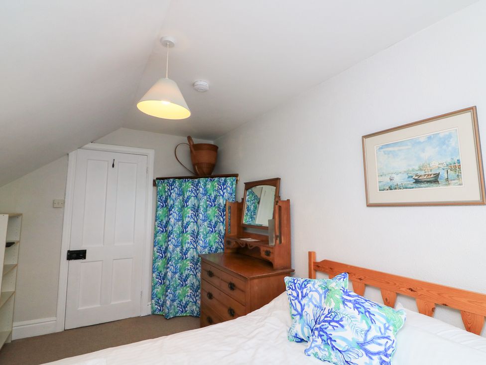 A bedroom with a bed and dresser at Waders Salcombe