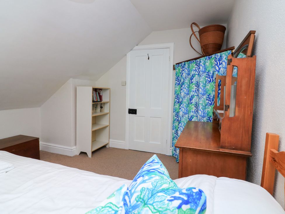 A bedroom with a dresser and bookshelf at Waders in Salcombe