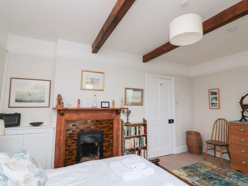 A bedroom with a bed and fireplace at Waders in Salcombe