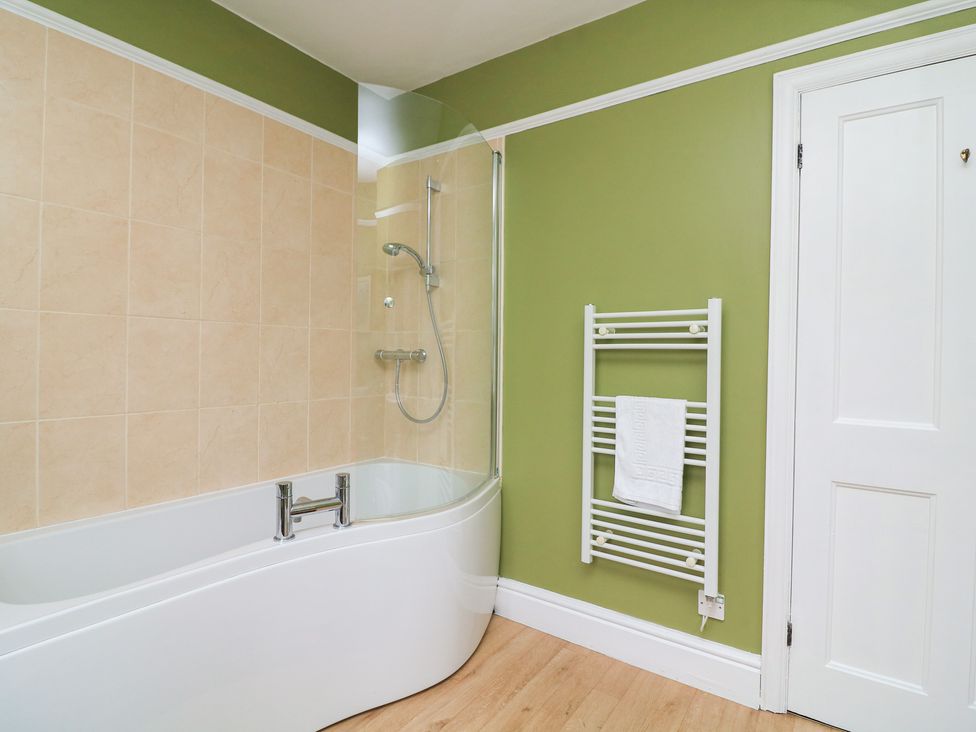 A bathroom with a bathtub and towel rail at Waders in Salcombe